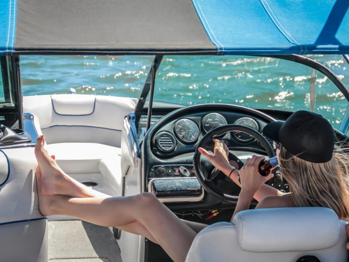 a woman steering a white speedboat