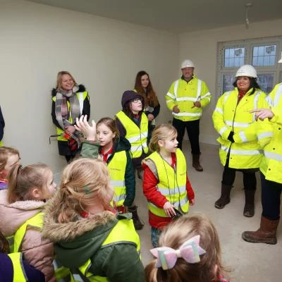 area sales manager matt gould showing children from tattenhall rainbows around the construction site at redrow39s meadow brook development credit  leeboswellphotographycom