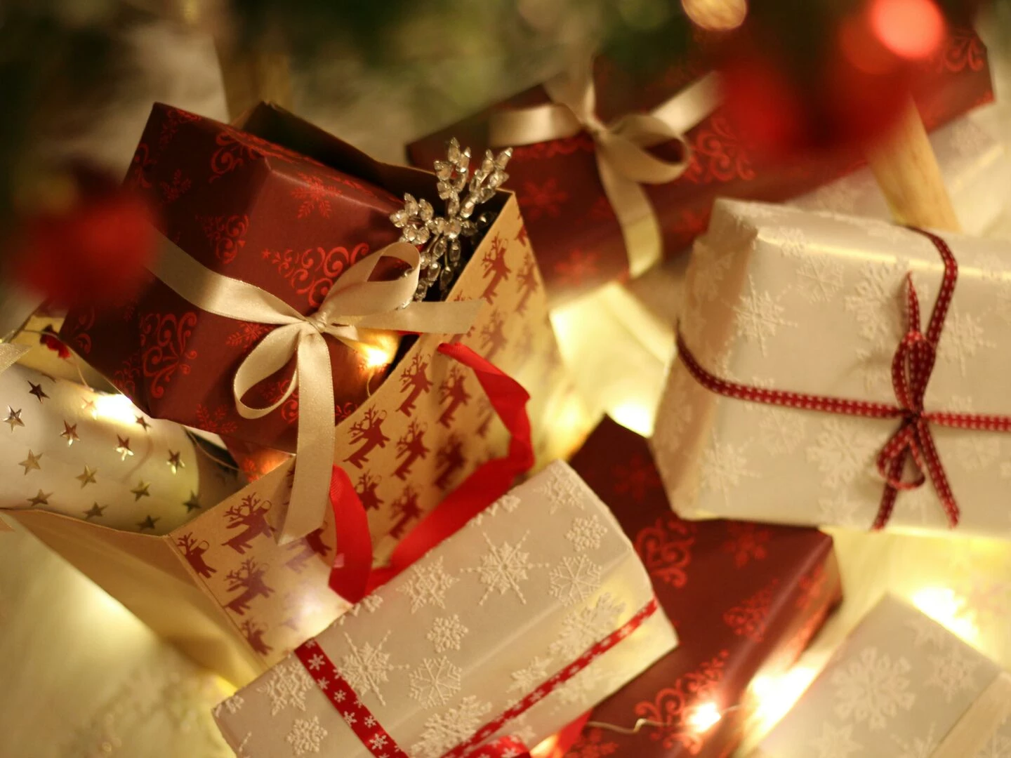 beautifully wrapped christmas presents under the tree with festive decorations and ribbons