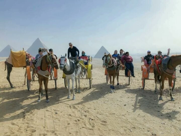 People Riding Horses while Touring Around the Desert