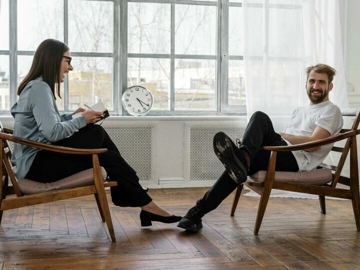 Counselor and client in a positive therapy session in a well-lit room.