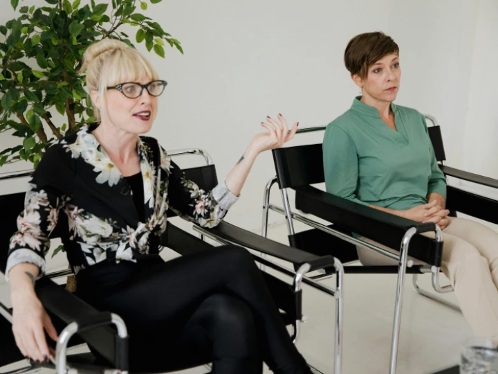 Women Sitting on Chairs in a Modern Interior and One Woman Talking