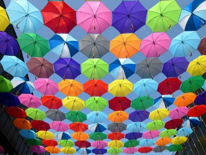 Yellow Blue Red Pink Purple Green Multicolored Open Umbrellas Hanging on Strings Under Blue Sky