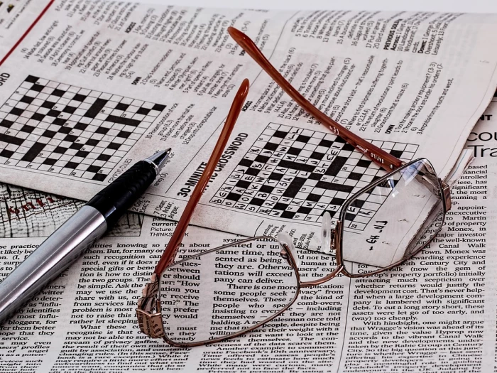 newspaper crossword with glasses