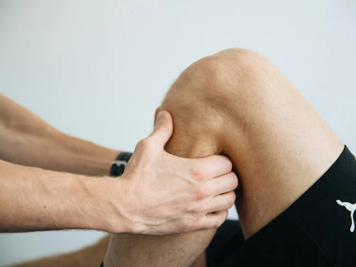 A man is doing a knee massage on a patient