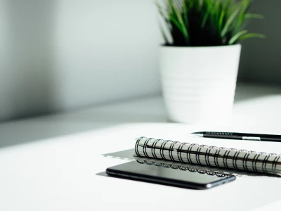 Pen, notebook and phone on a desk