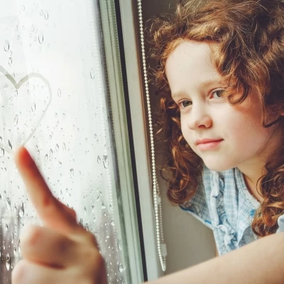 Child at window in rain