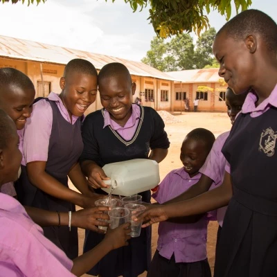 children at st balikuddembe school enjoying water from their new tank  copyright all we can