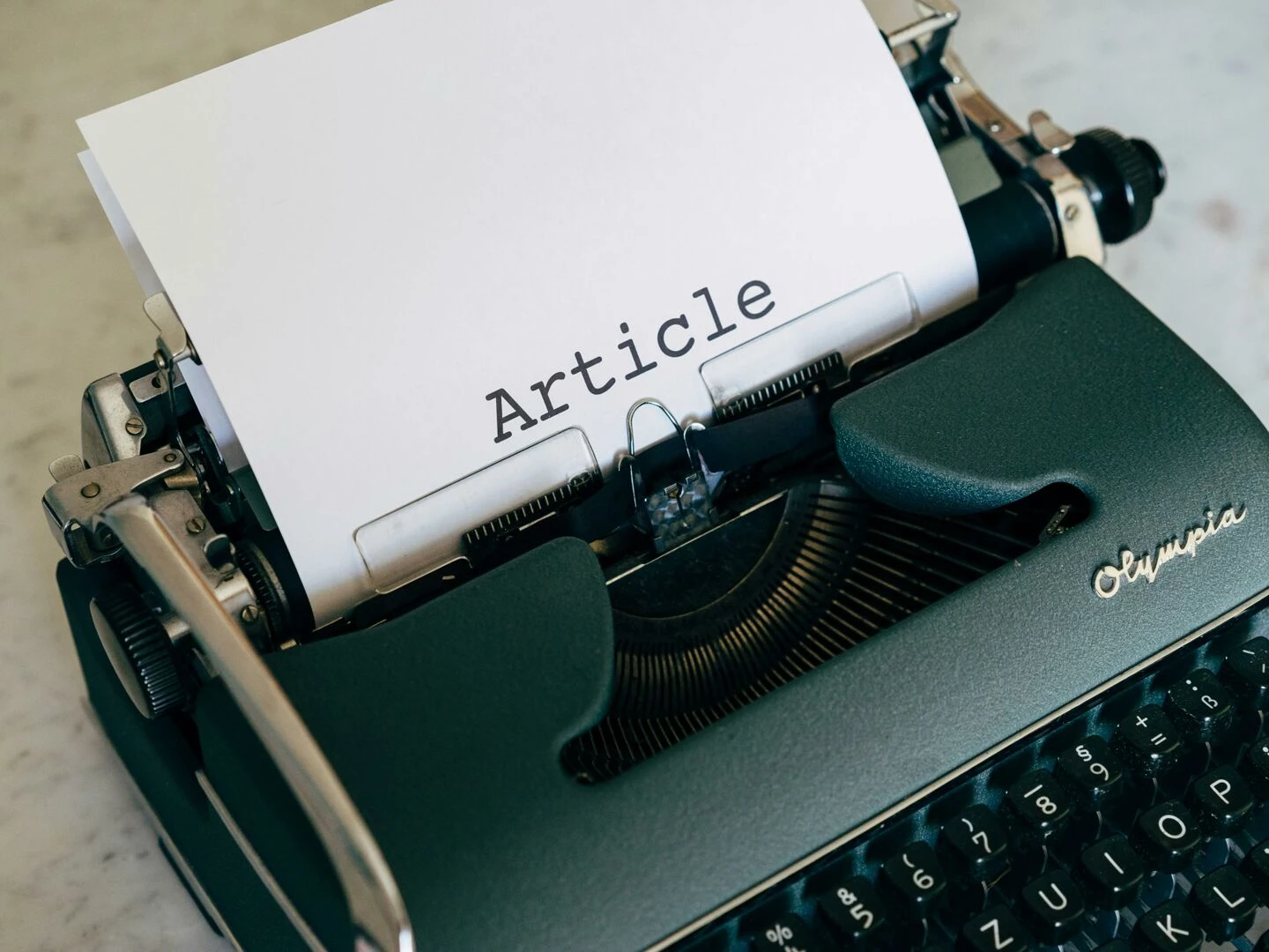 closeup of a vintage typewriter with a paper sheet displaying 39article39 in retro font