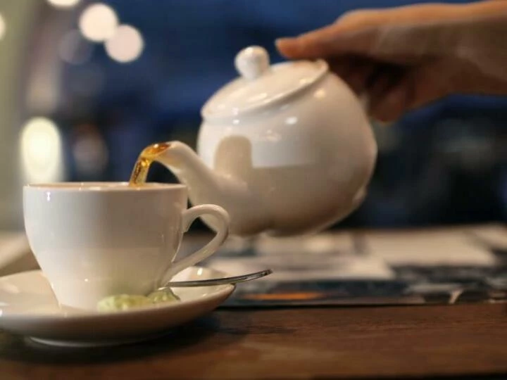 closeupshotoffemalehandpouringblackhotteafromthepotintothecupxk8fqbybf0000