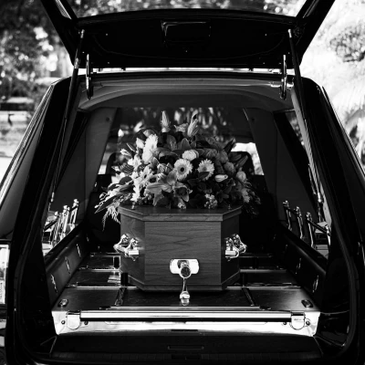 coffin in hearse with flowers