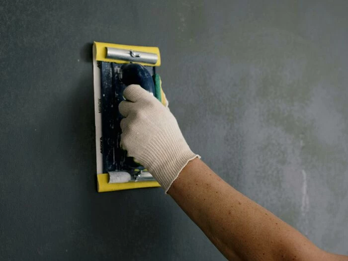 crop man scarpering gray wall in flat