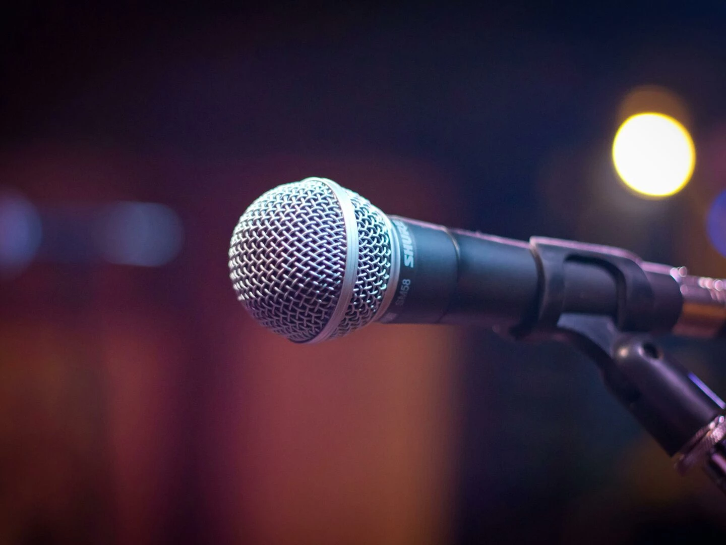 dynamic microphone on stand with blurred stage lights in background
