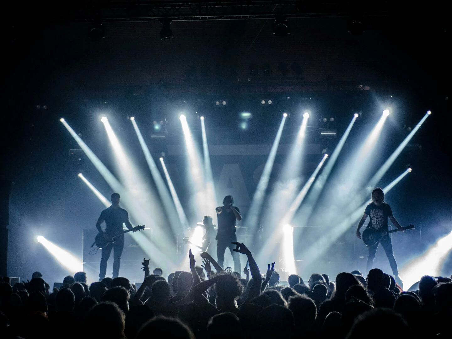 energetic live concert with musicians performing on stage engaging the crowd with vibrant lighting effects