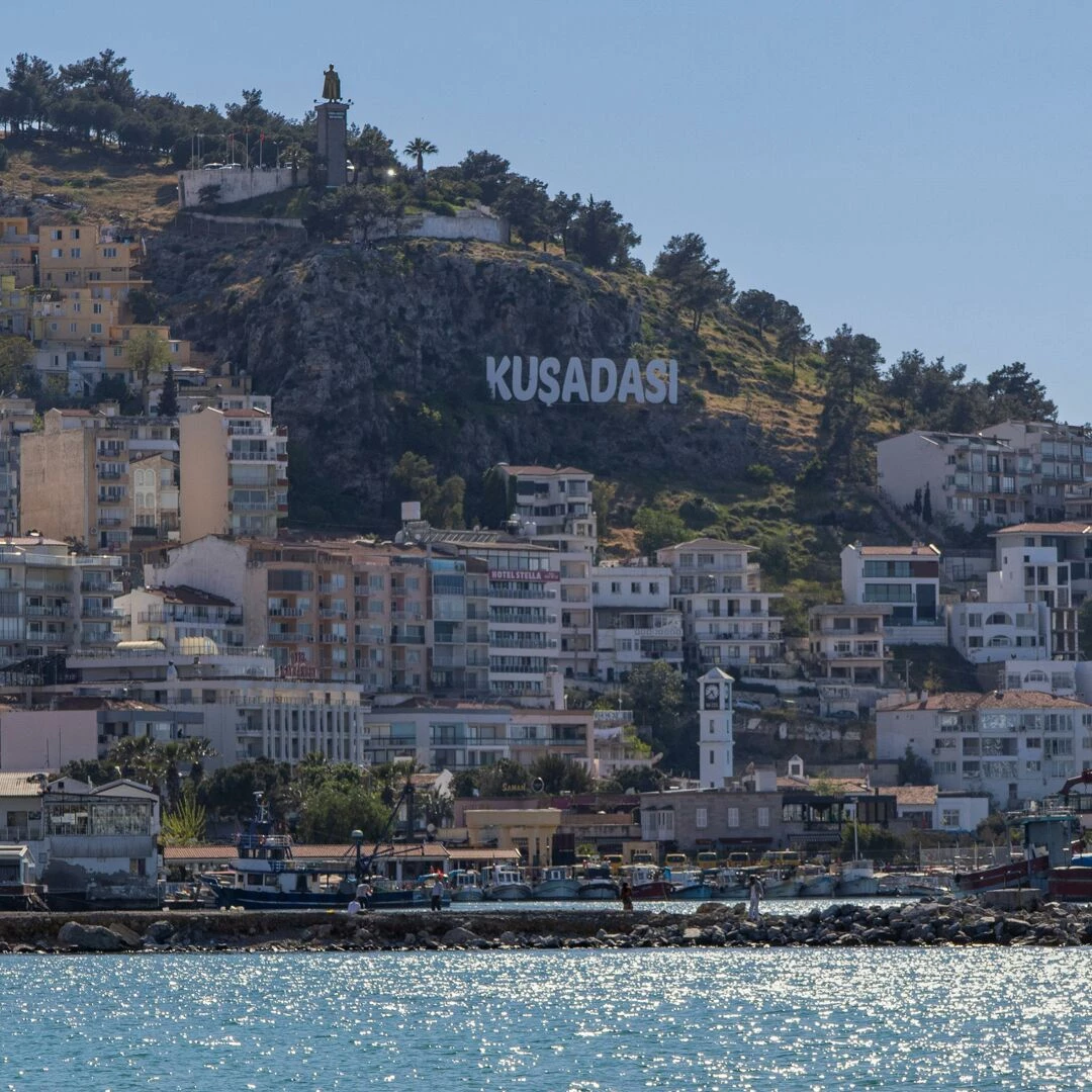 explore the vibrant seafront buildings and lush hillside of kusadasi turkey