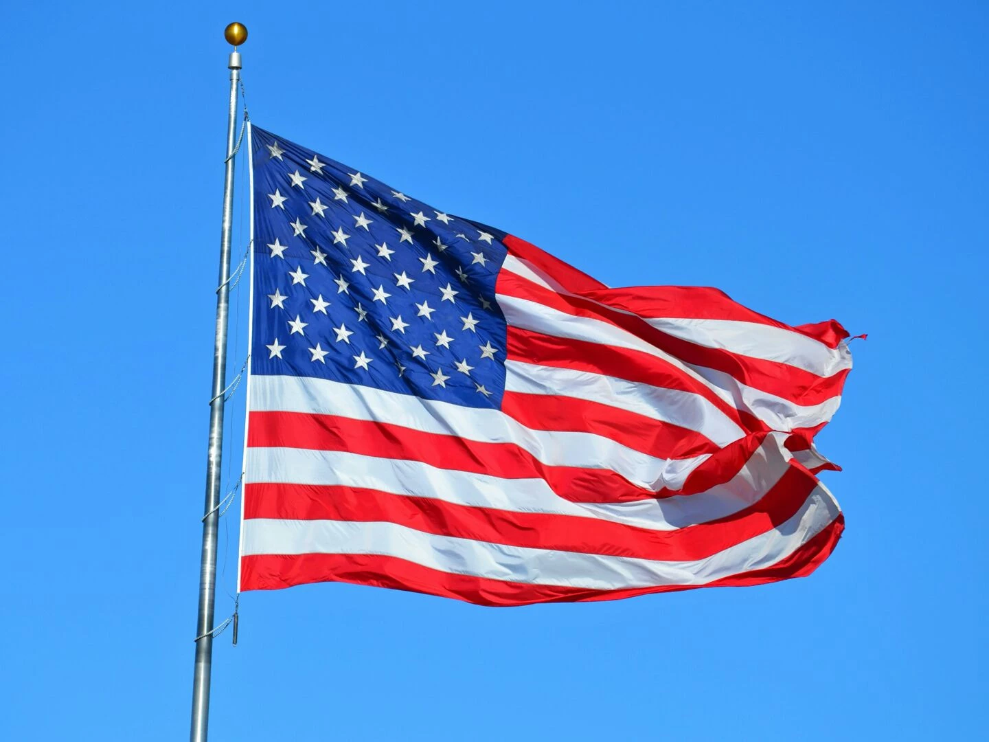 majestic american flag waving against a bright blue sky symbolizing freedom and patriotism