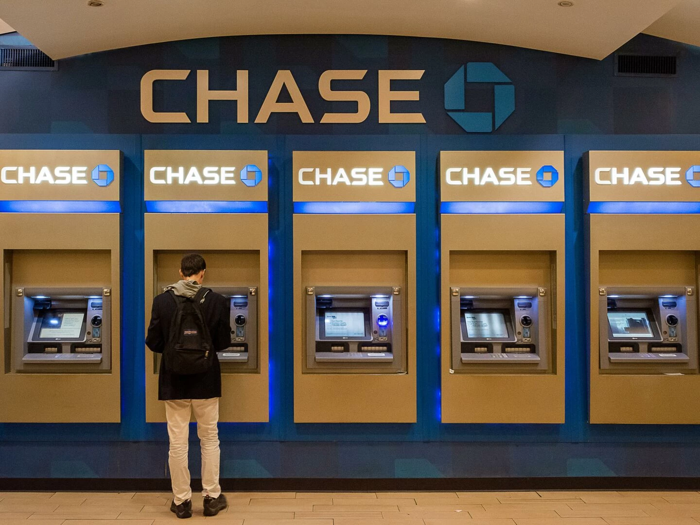 male customer using chase atm machine in an urban indoor setting
