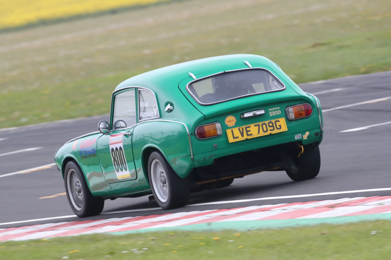 rear of green race car at castle combe april 2024