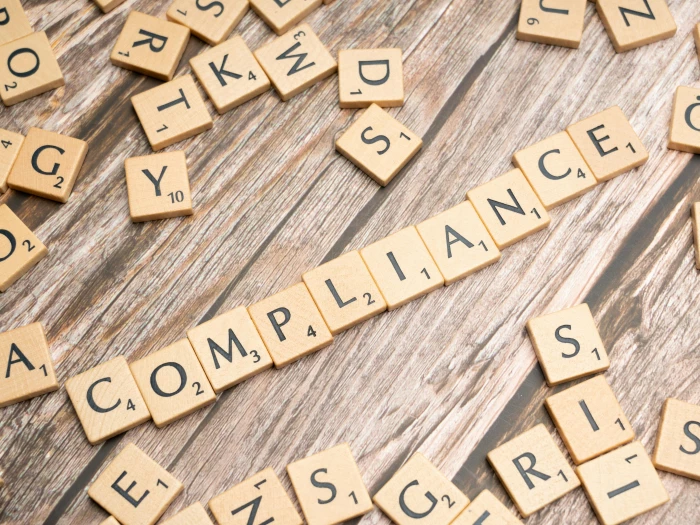 the word compliance written in scrabble letters