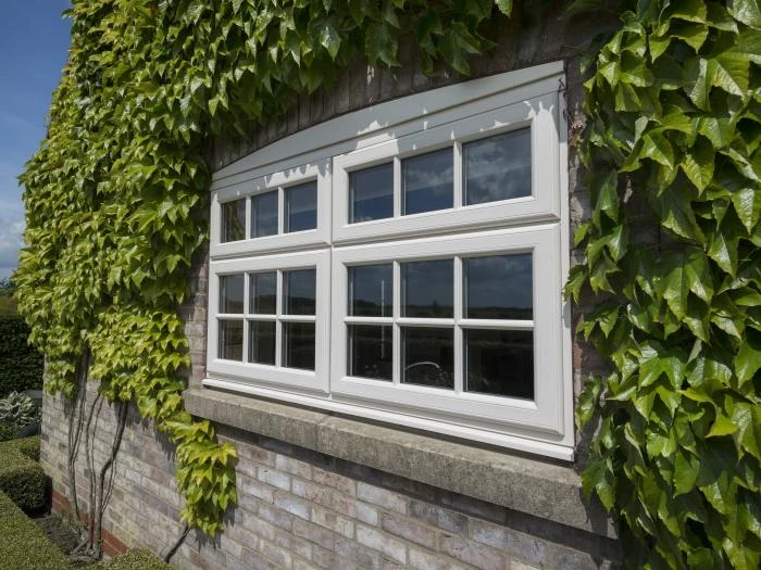 white upvc window with ivy covered wall